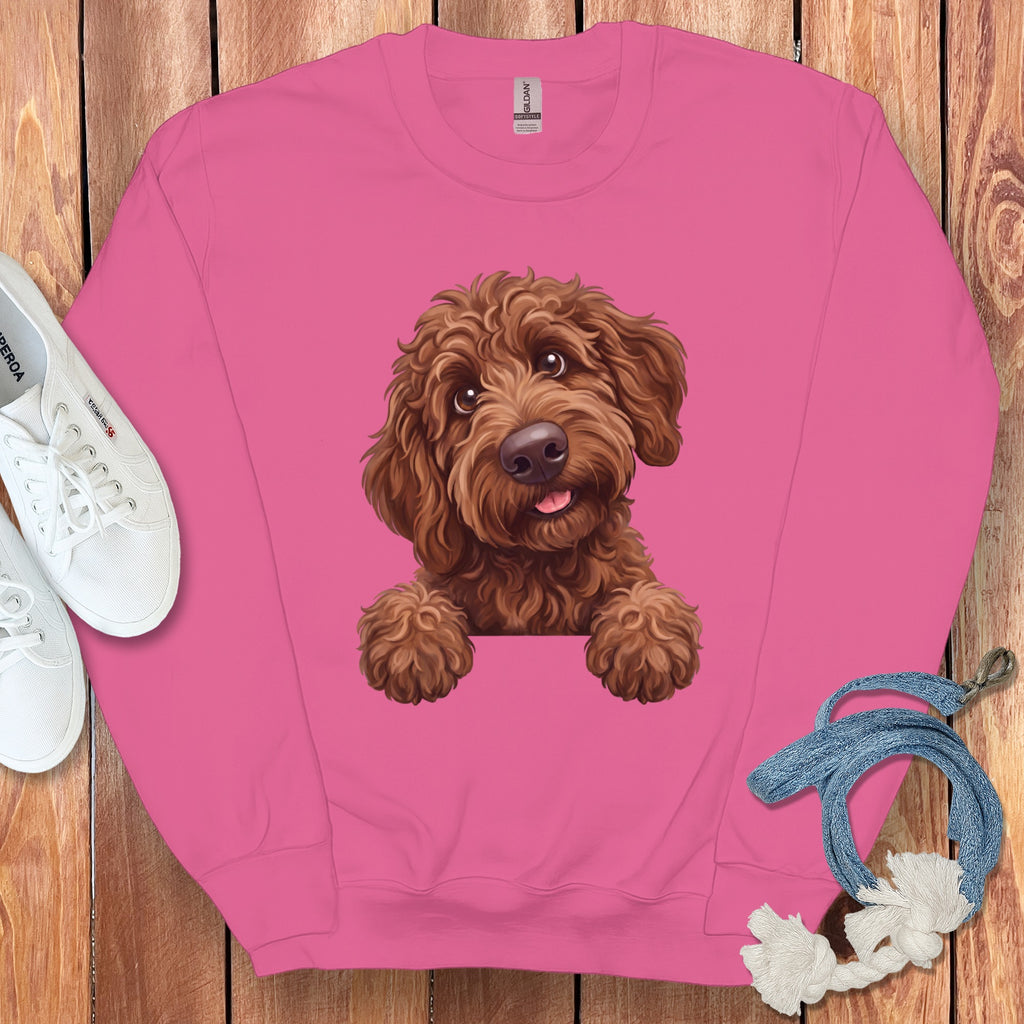 Pink sweatshirt with a drawing of a brown, fluffy dog peeking over the front.
