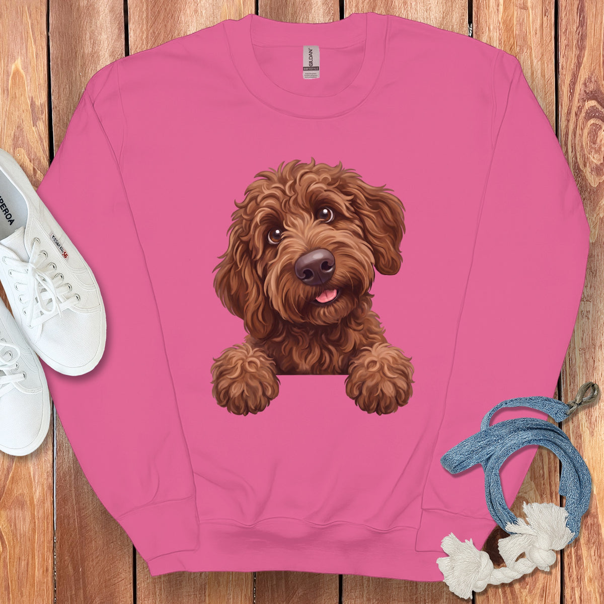 Pink sweatshirt with a drawing of a brown, fluffy dog peeking over the front.