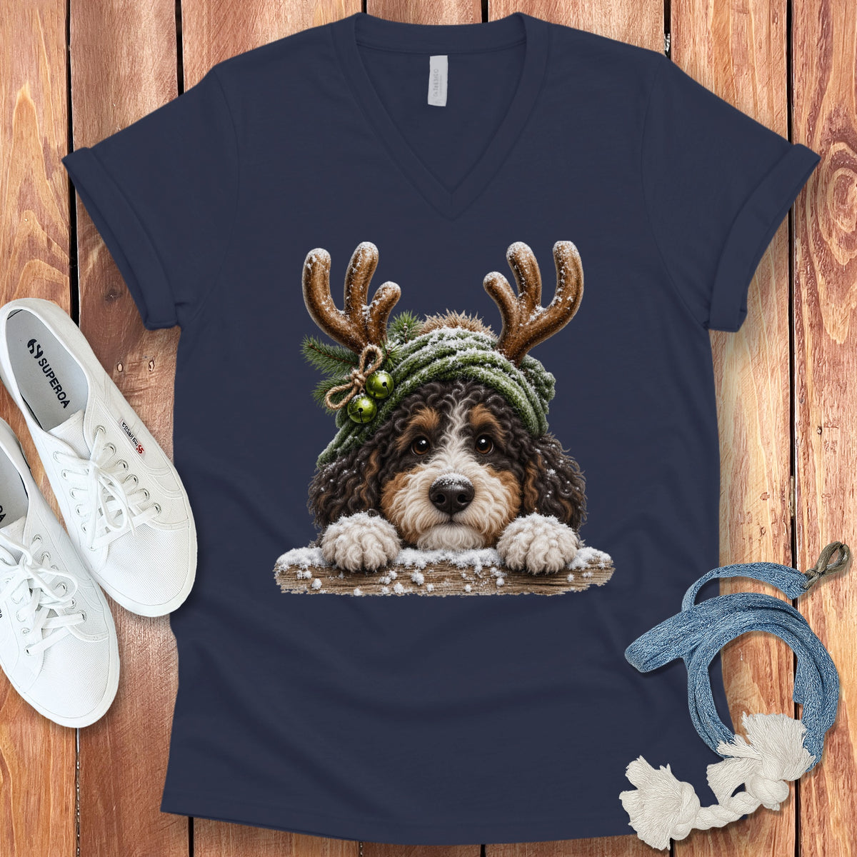 Bernese Mountain Dog wearing antlers and a Santa hat on a navy t-shirt.