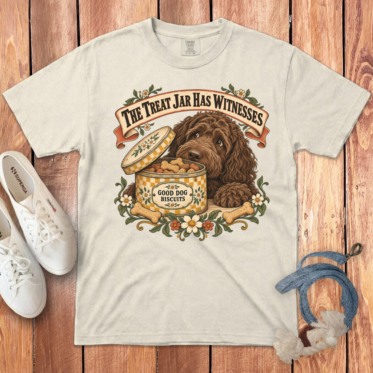 A cream t-shirt with a graphic of a brown dog beside an open treat jar.