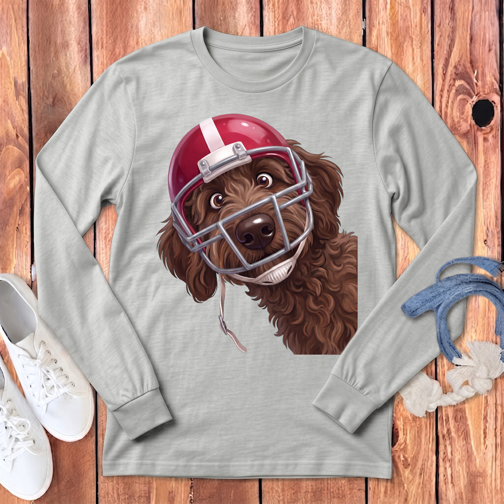 Brown dog wearing a red football helmet and face mask on a gray shirt.