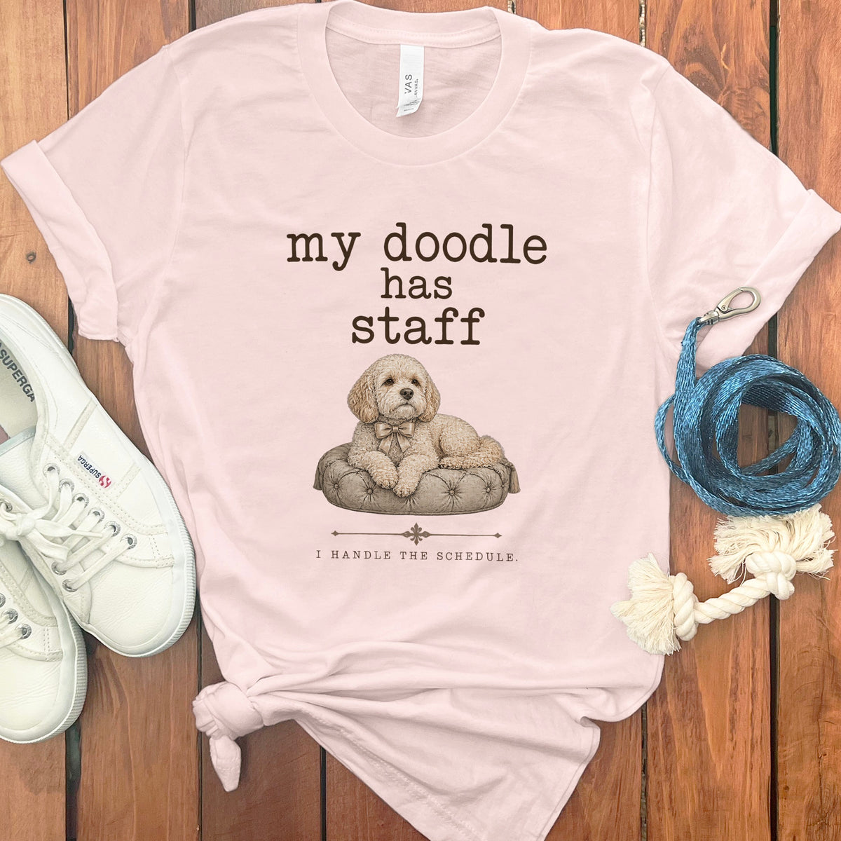 Light pink t-shirt with "my doodle has staff I HANDLE THE SCHEDULE." text and dog graphic.