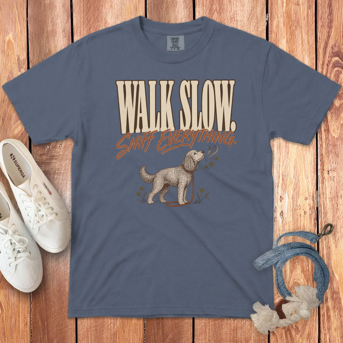 A blue crewneck t-shirt displays the text Walk Slow Sniff Everything above a sniffing dog graphic.