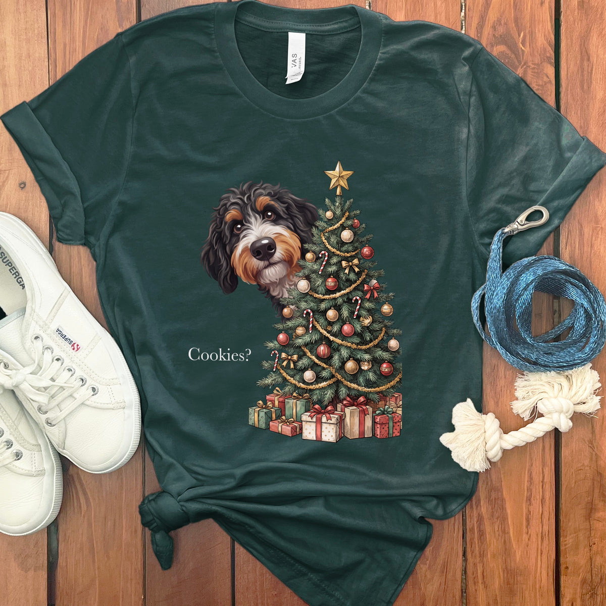 Dark green t-shirt with dog peeking from behind a Christmas tree and text "Cookies?".