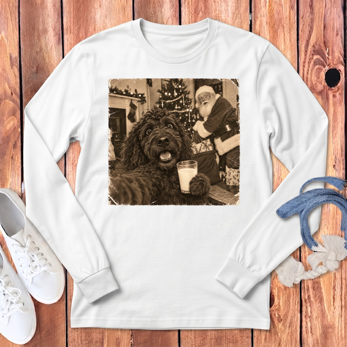 White long-sleeve t-shirt featuring a vintage sepia graphic of a curly dark dog holding a glass of milk with Santa Claus in the background.