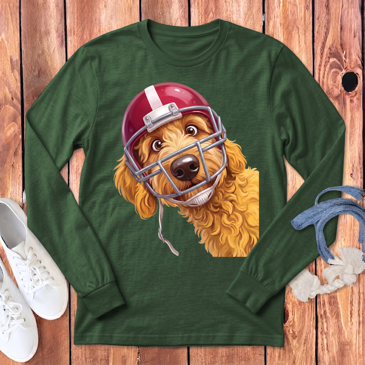 Golden doodle dog wearing a red football helmet on a green long-sleeve shirt.