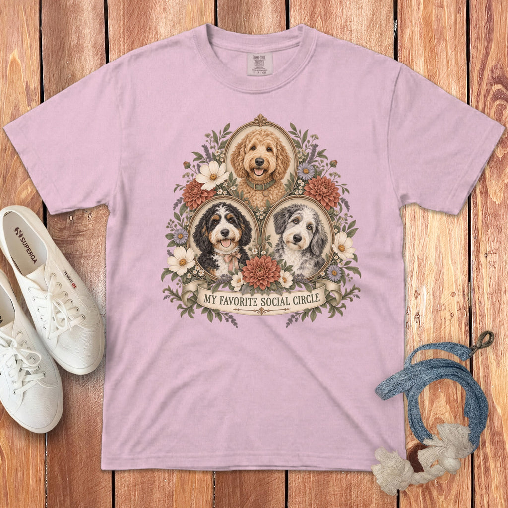 A pink t-shirt featuring three dog portraits surrounded by vintage floral frames and the text My Favorite Social Circle.