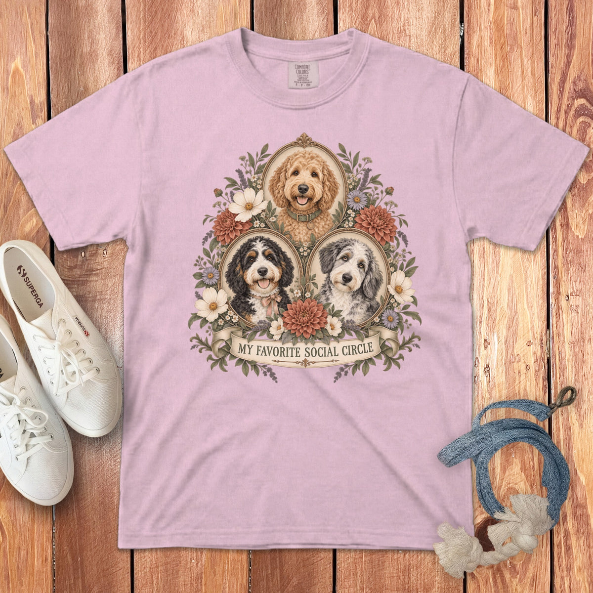 A pink t-shirt featuring three dog portraits surrounded by vintage floral frames and the text My Favorite Social Circle.