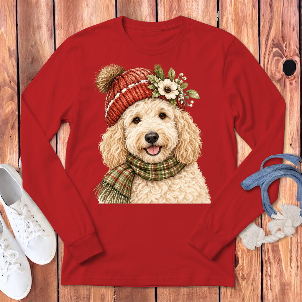 Goldendoodle dog wearing a red knit hat and plaid scarf, front view.