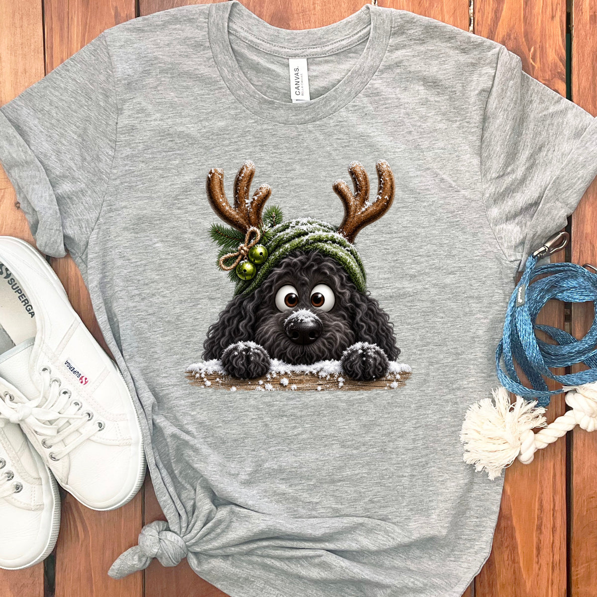 Grey t-shirt with a cartoon black dog wearing reindeer antlers and a green beanie.