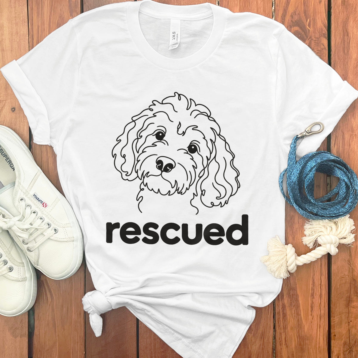 White t-shirt with a line drawing of a dog and the word "rescued".