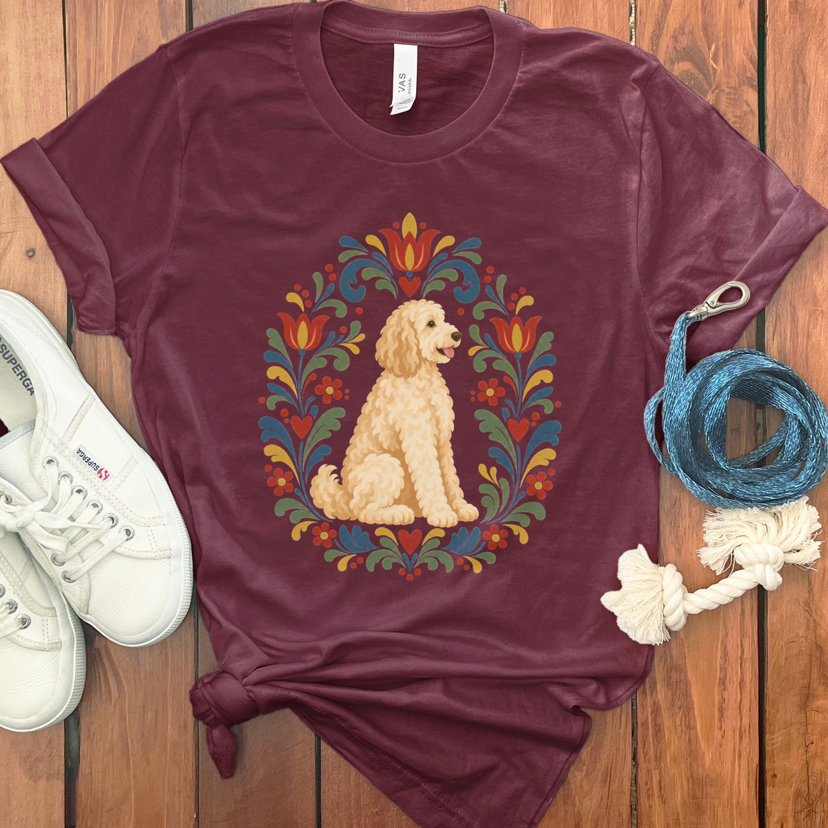 Maroon t-shirt with a cream dog in a colorful floral circular design.
