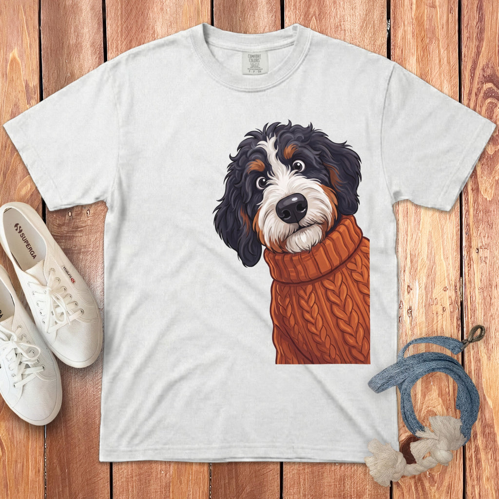 White T-shirt with a cartoon Bernese Mountain Dog wearing an orange knitted sweater.