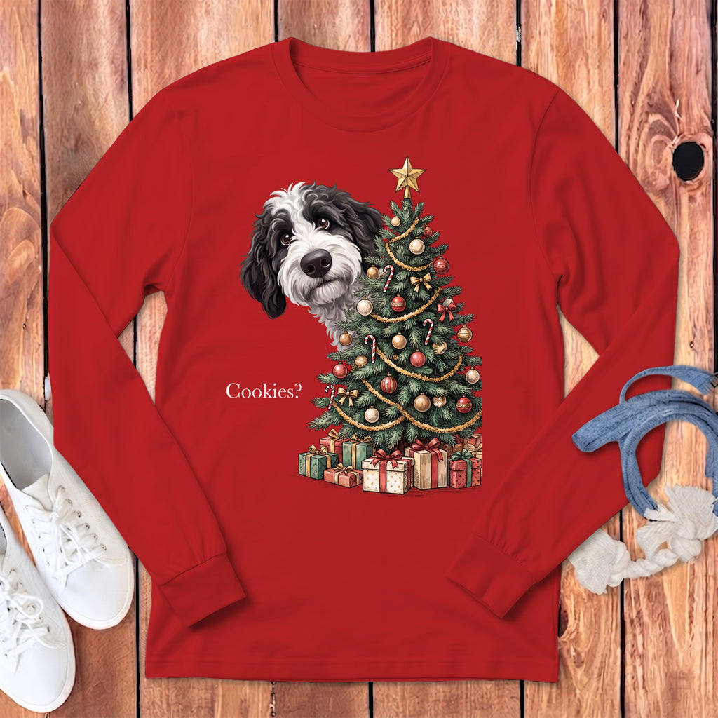 Black and white dog peeks from behind a decorated Christmas tree with presents.