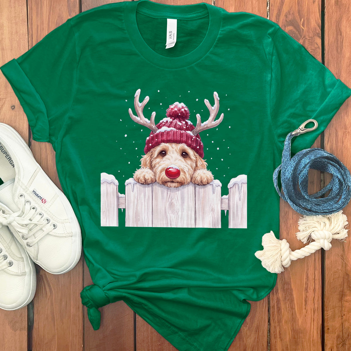 Green t-shirt with a doodle dog wearing antlers and a beanie.