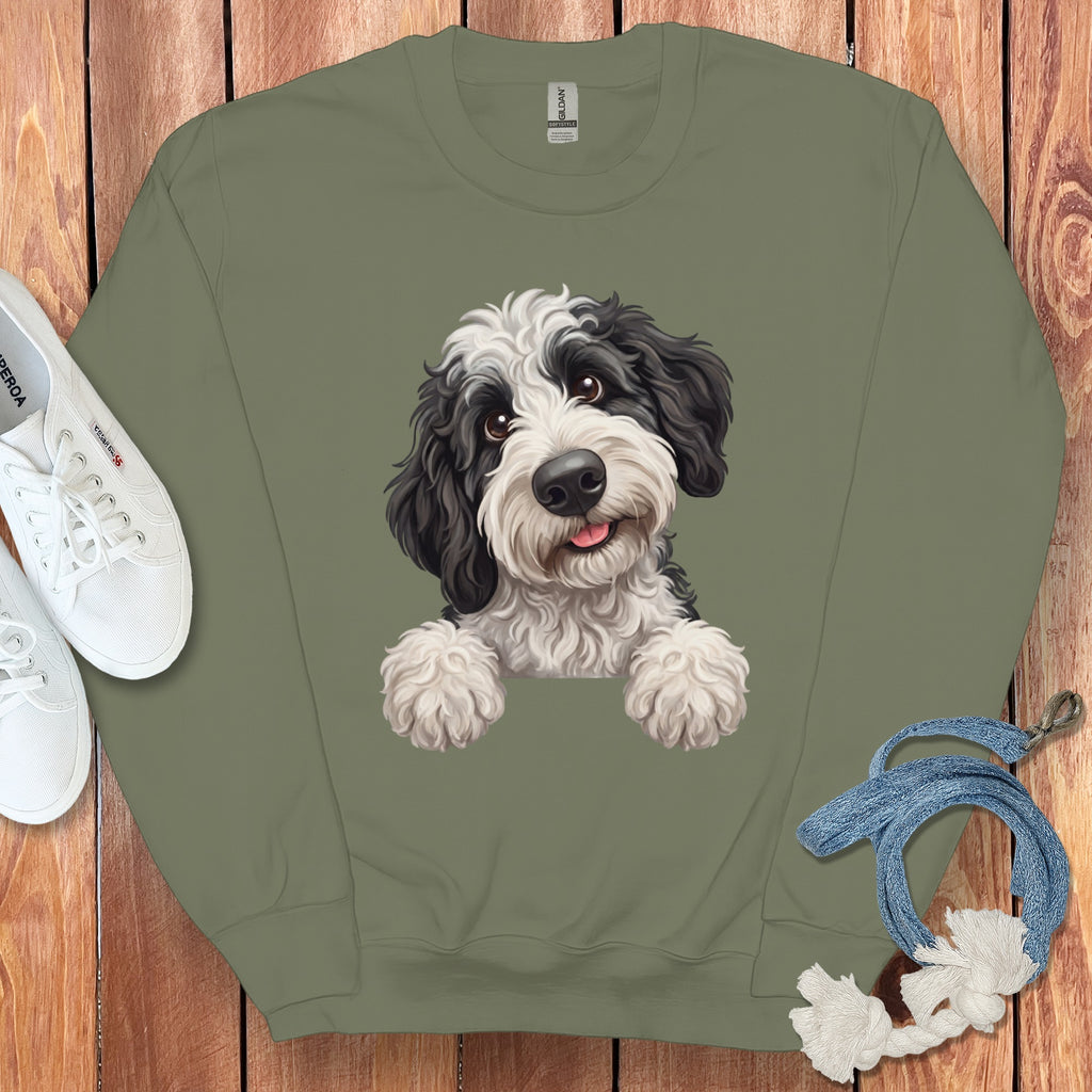 Green crewneck sweatshirt with a black and white dog illustration and white sneakers.