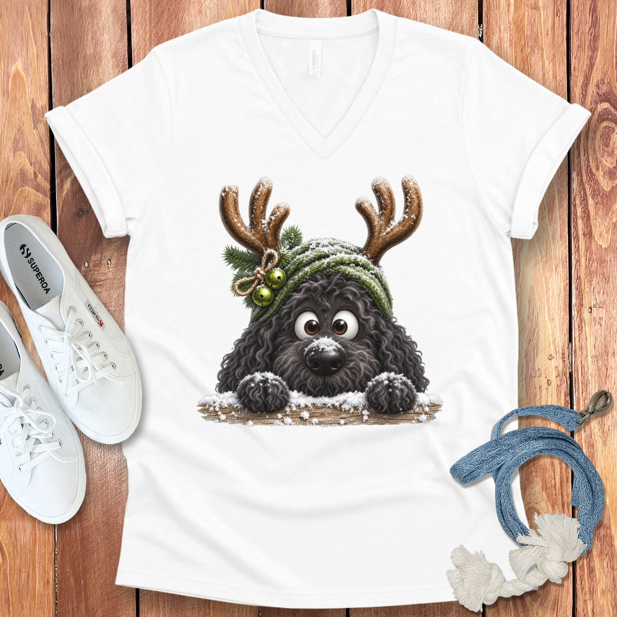 T-shirt with a fluffy black dog wearing reindeer antlers and a green hat.