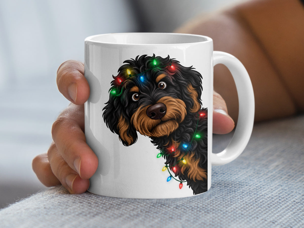 White mug with a black and brown doodle dog wrapped in colorful Christmas lights.