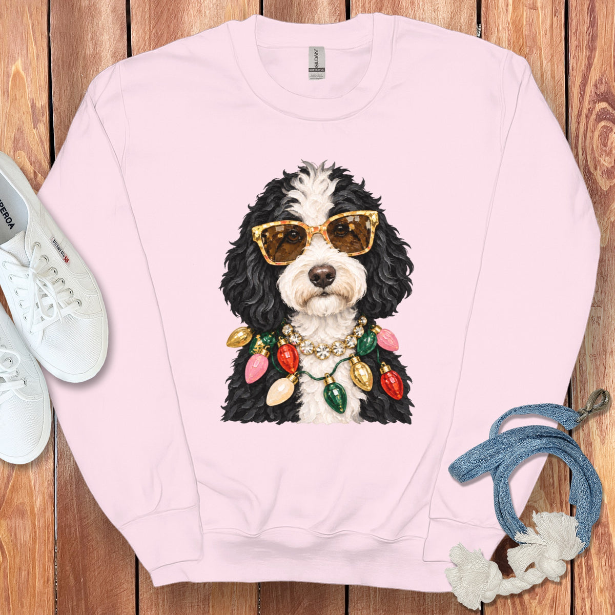 Pink sweatshirt with a black and white dog wearing sunglasses and Christmas lights.