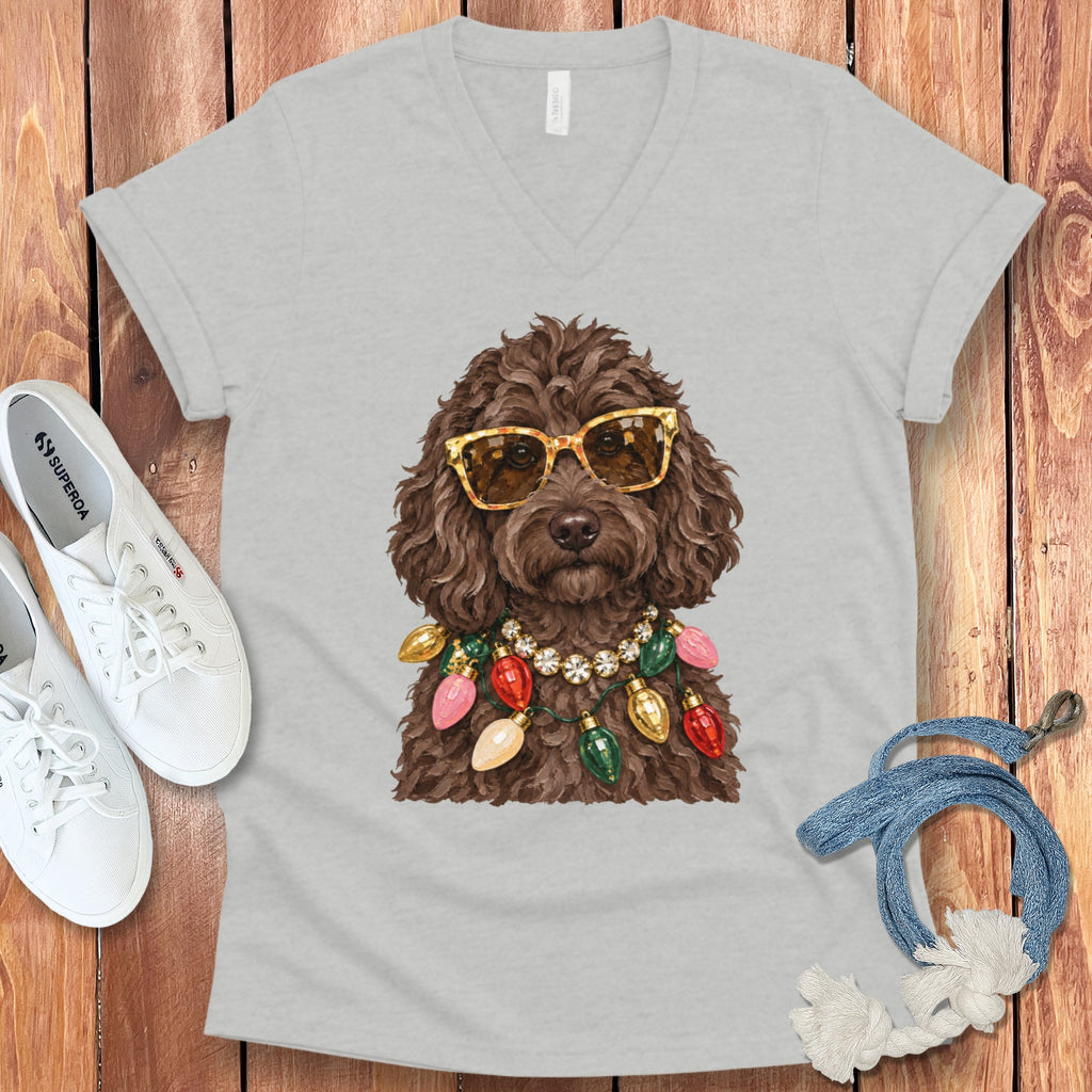 Brown dog wearing sunglasses and a string of Christmas lights on a gray v-neck t-shirt.