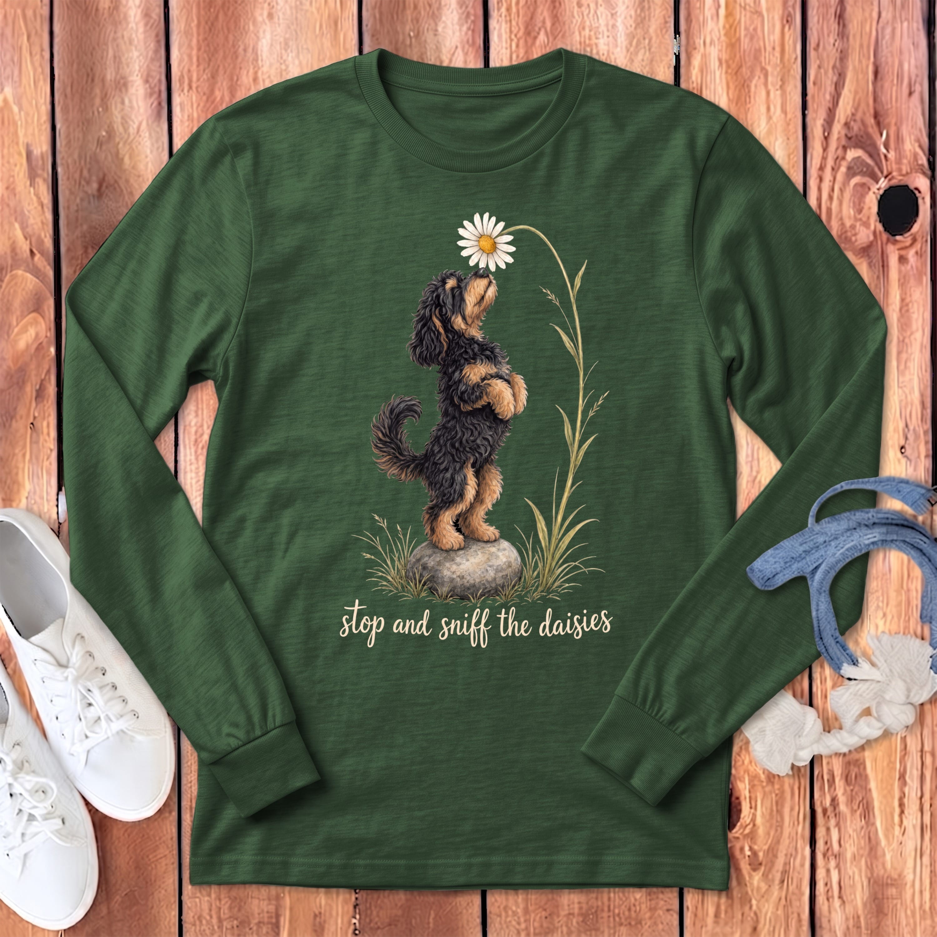 Dark green long-sleeve shirt with a dog sniffing a daisy and text "stop and sniff the daisies".
