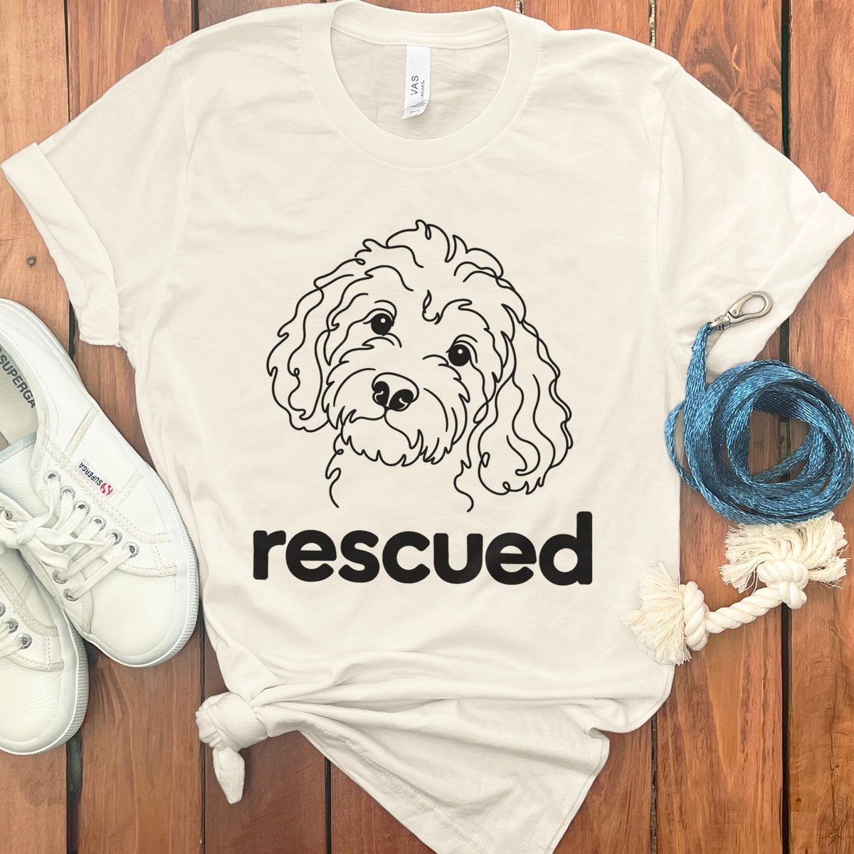 White t-shirt with a line drawing of a dog and the word "rescued".