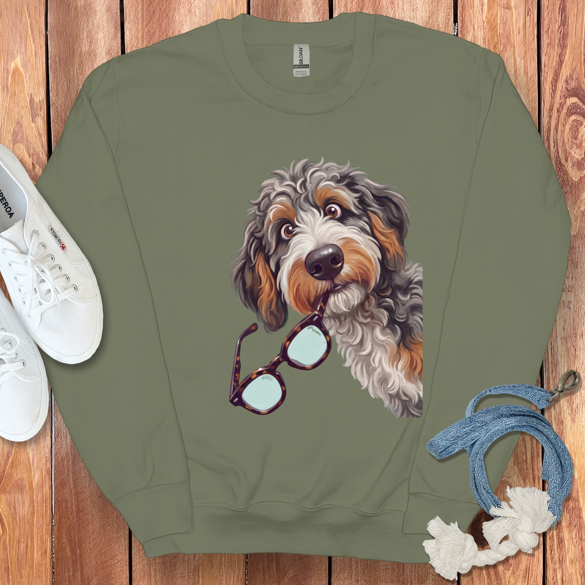Olive green crewneck sweatshirt featuring a graphic of a fluffy dog holding glasses in its mouth.