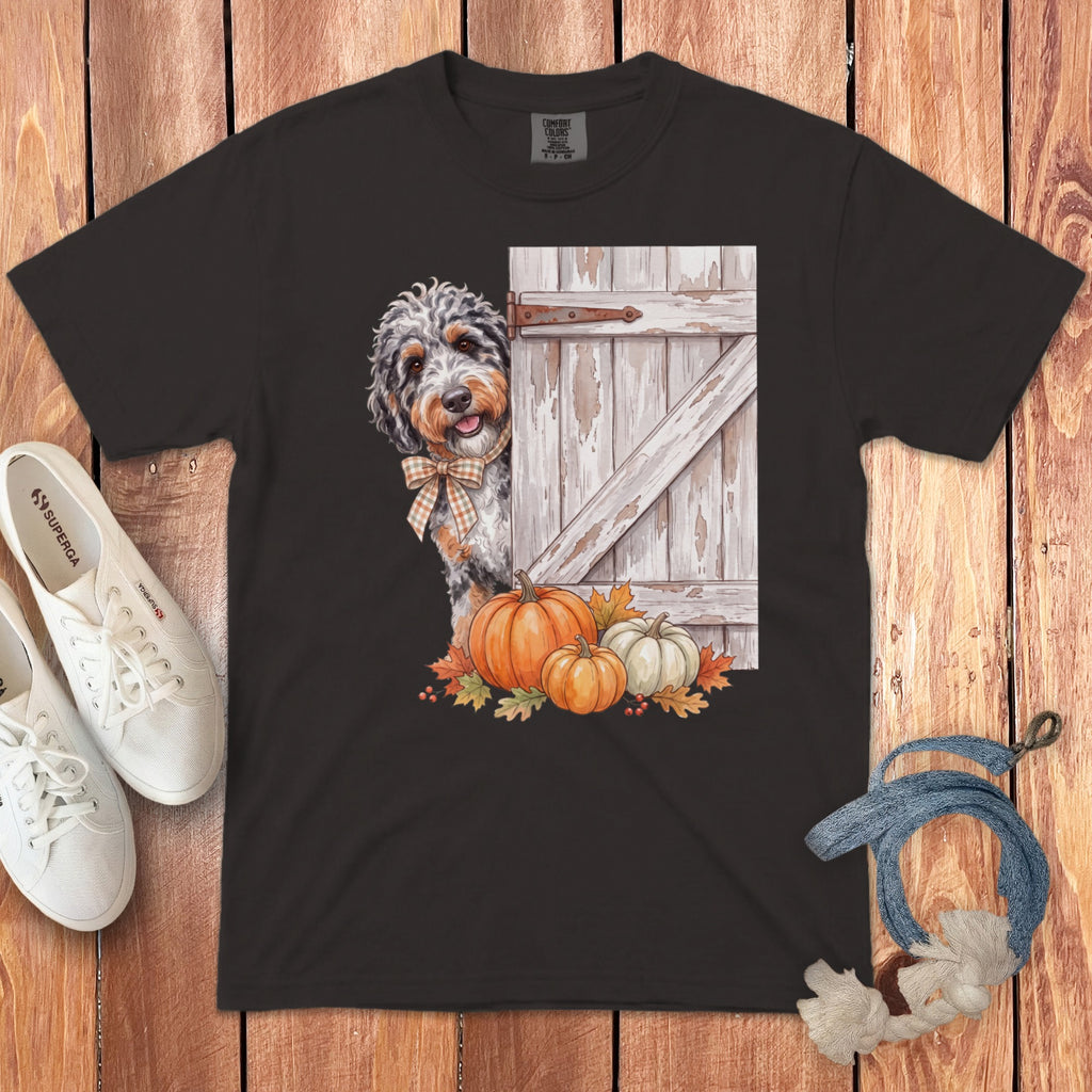 Dog with bow tie peeking from behind rustic door with pumpkins and leaves.