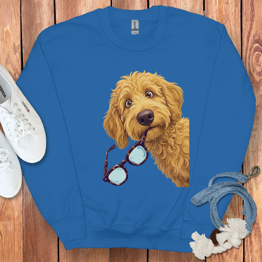A royal blue crewneck sweatshirt featuring an illustration of a fluffy golden dog holding glasses in its mouth.