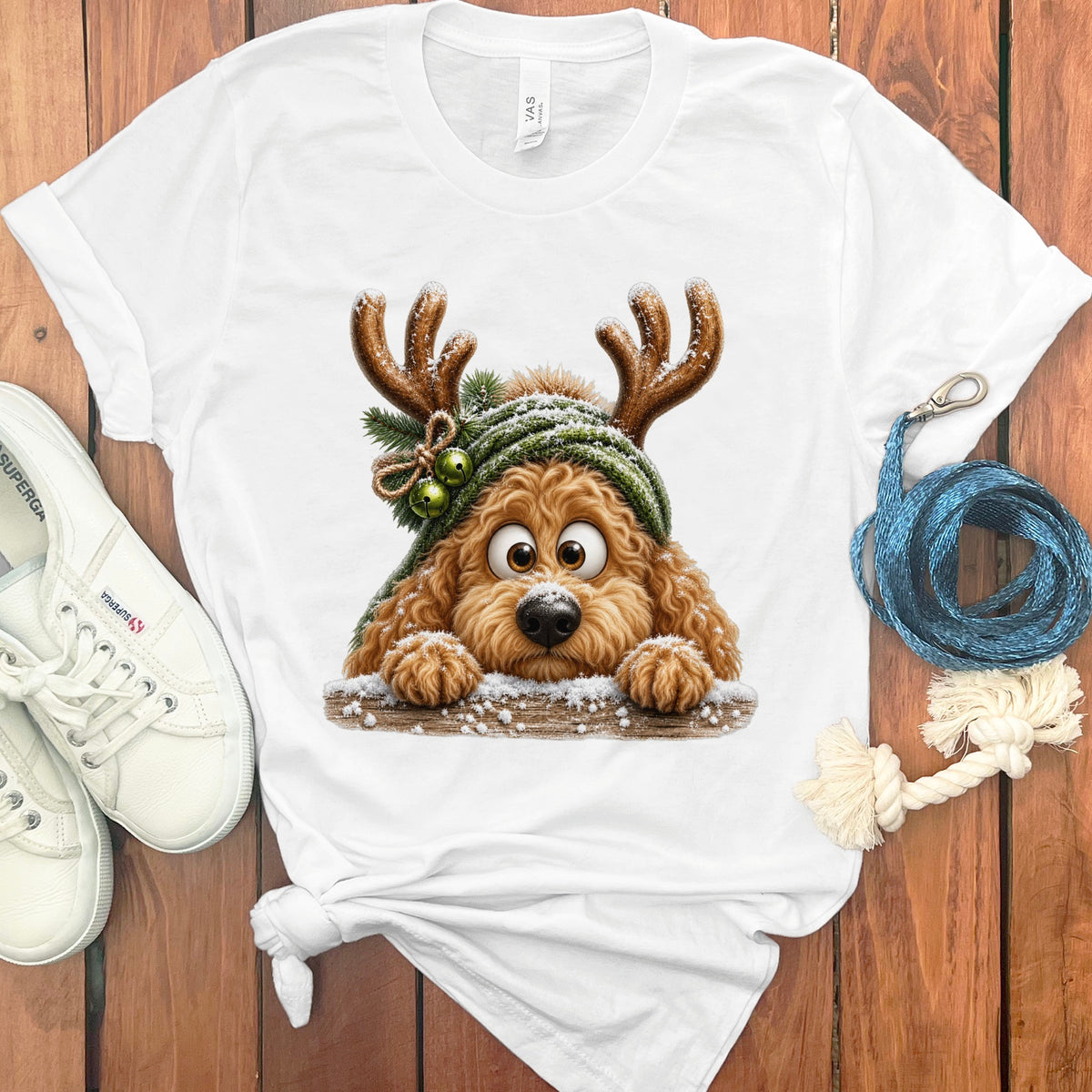 White t-shirt with graphic of a dog wearing reindeer antlers and a green hat.