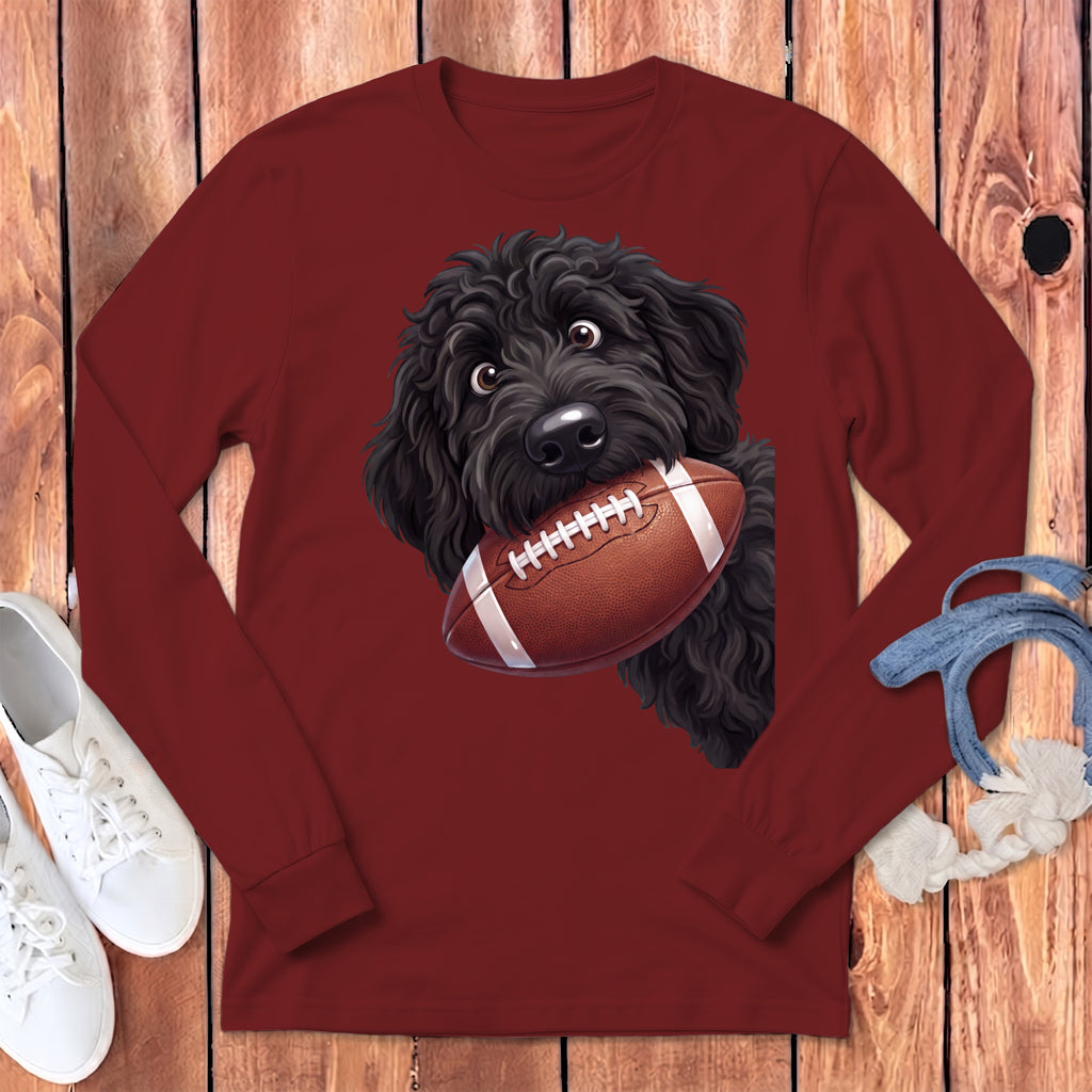 Black dog with football in its mouth on a maroon long-sleeve shirt.