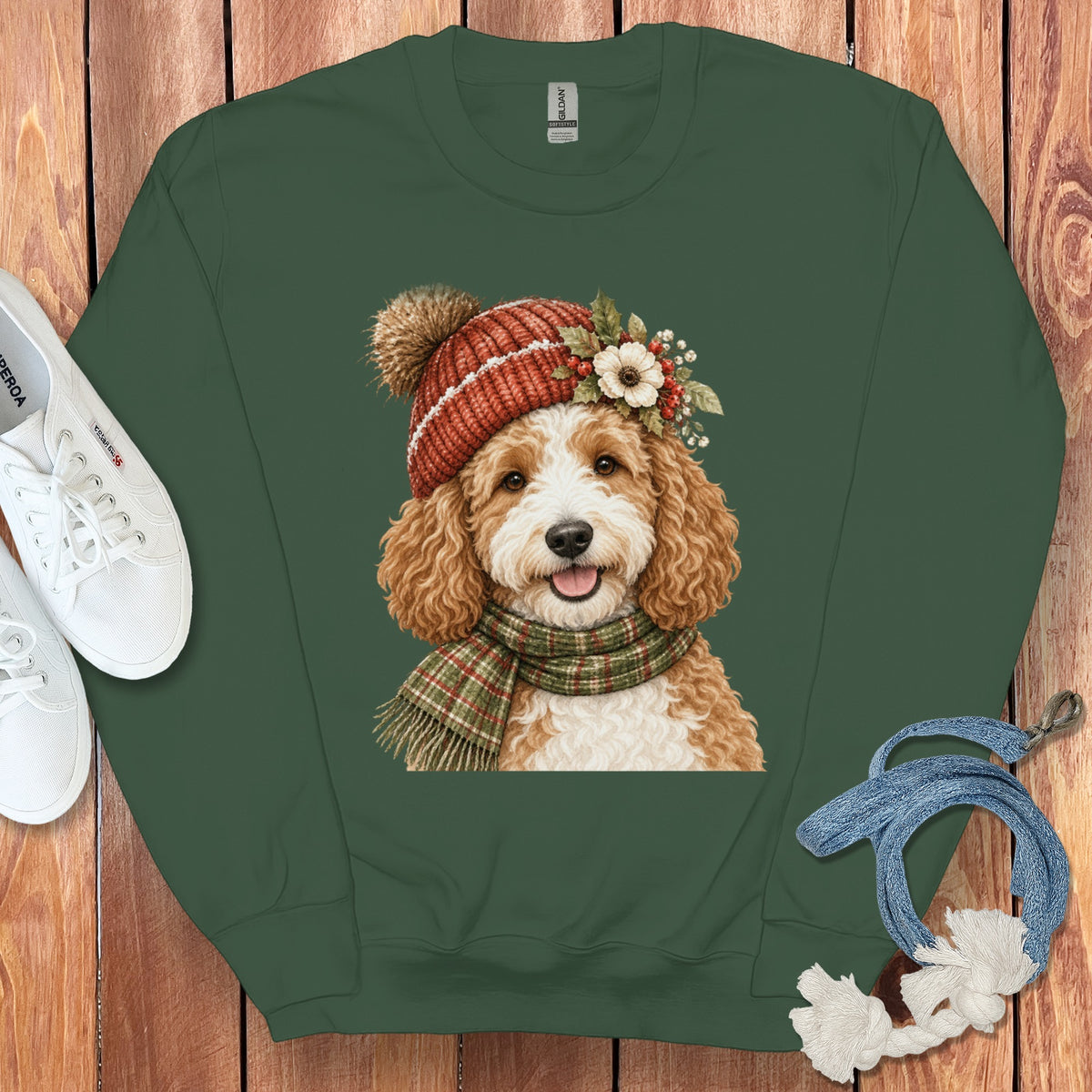 Green crewneck sweatshirt with a watercolor print of a golden doodle wearing a winter hat and scarf.