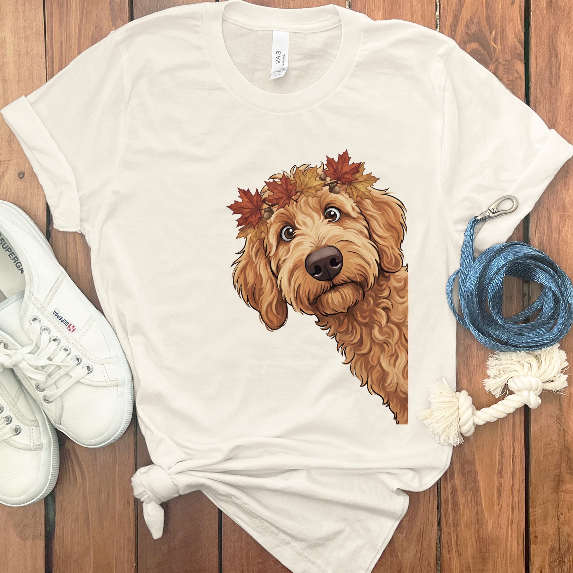 Cream t-shirt with illustration of a golden doodle wearing a fall leaf crown.