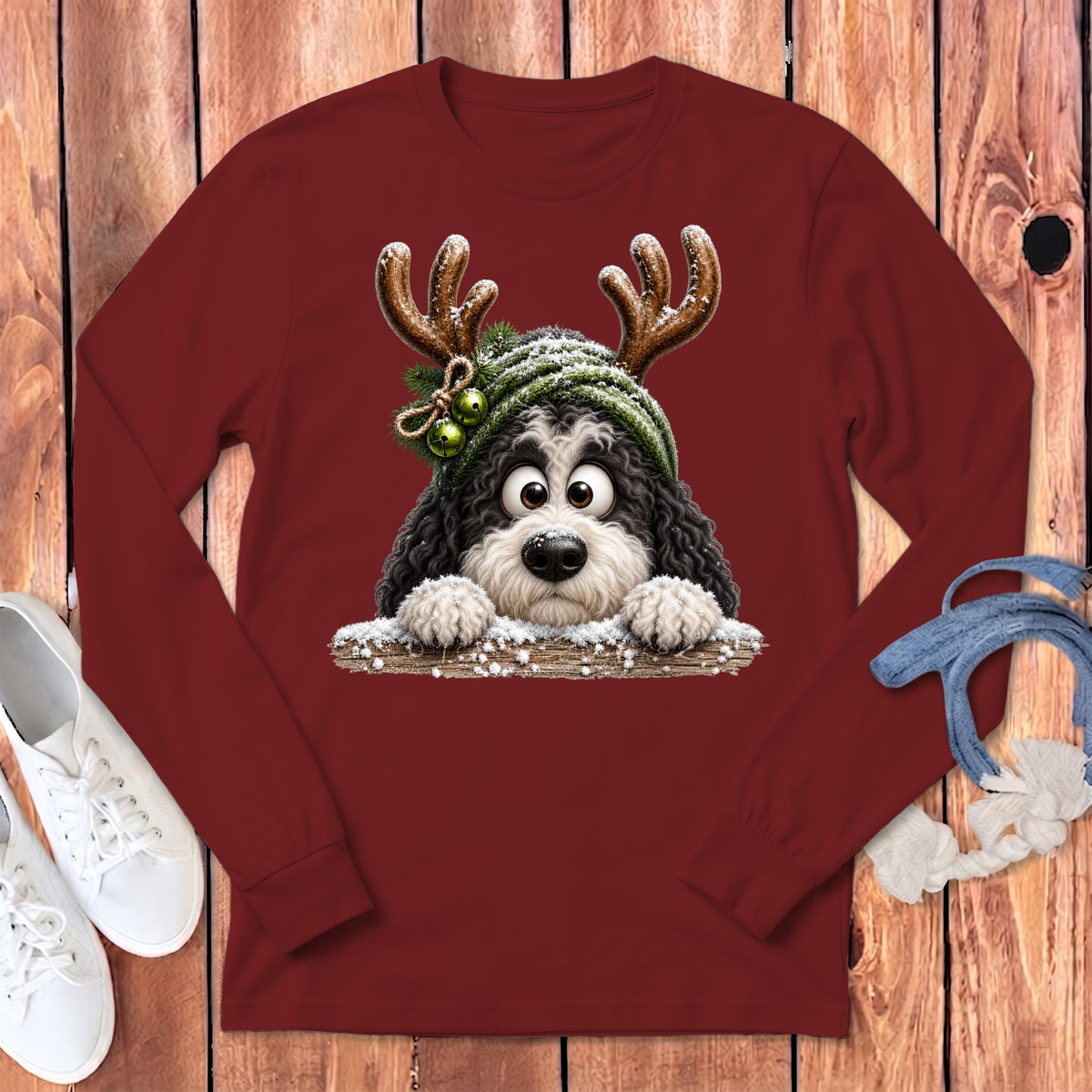 Maroon long-sleeve shirt with a fluffy dog wearing reindeer antlers and a snow-covered hat.