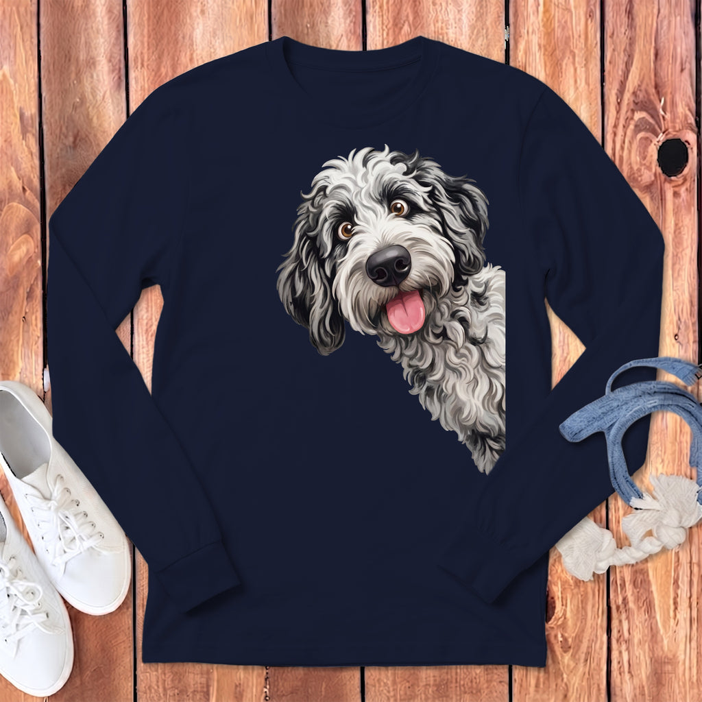 Black and white doodle dog peeking from behind navy long-sleeve shirt.