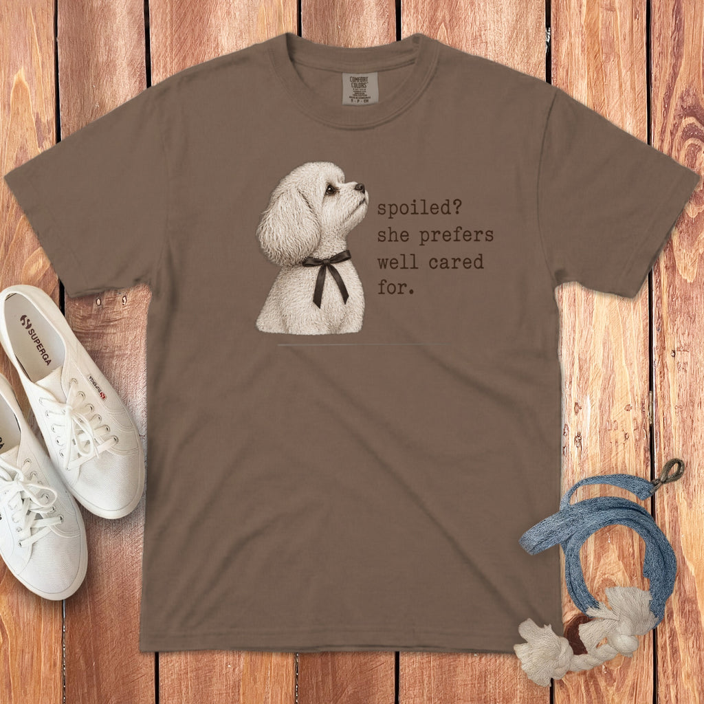 Brown short-sleeved t-shirt featuring a graphic of a white poodle wearing a bow and text saying "spoiled? she prefers well cared for."