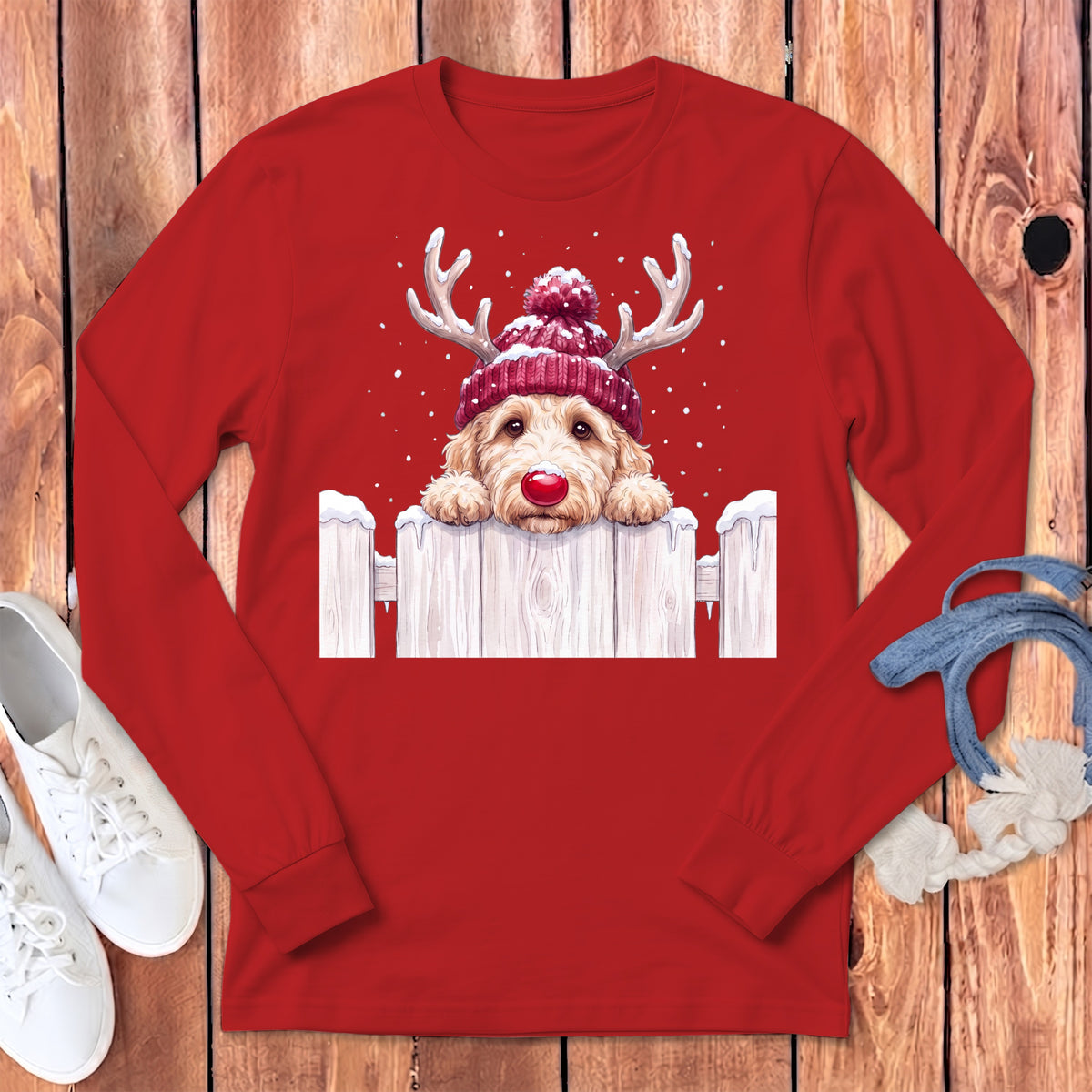 Goldendoodle dog wearing reindeer antlers and a red beanie with a red nose.