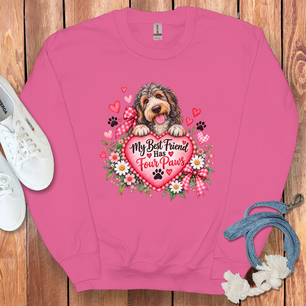 Pink sweatshirt with a graphic of a fluffy dog resting paws on a heart that reads My Best Friend Has Four Paws.