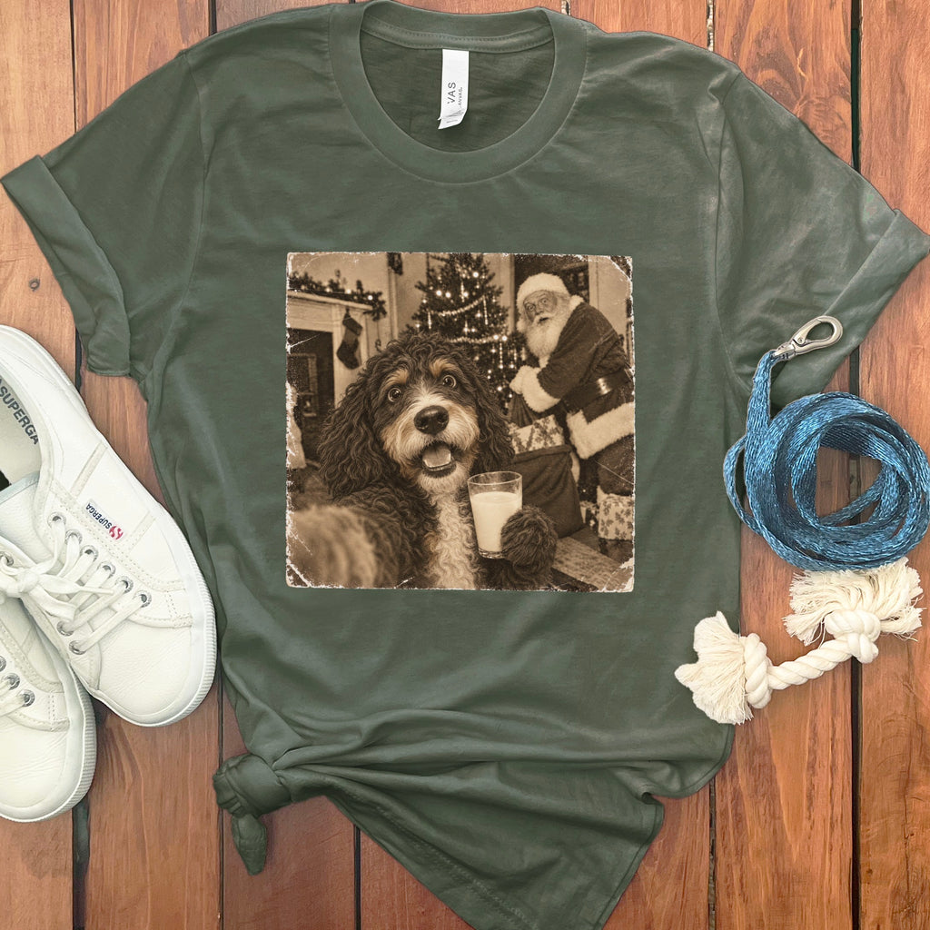 Olive green t-shirt featuring a graphic of a dog holding a glass of milk with Santa Claus in the background.