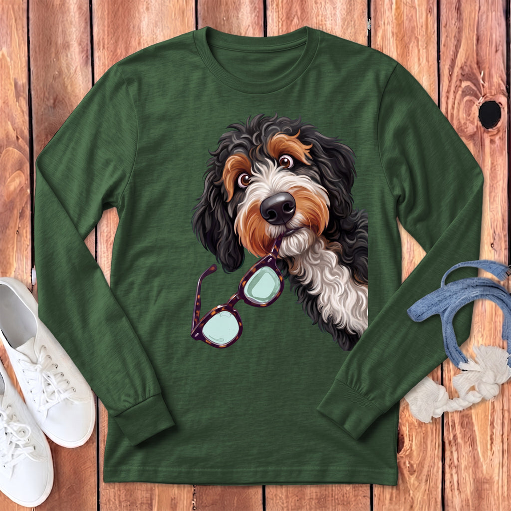 Dark green long-sleeve t-shirt featuring a graphic of a Bernedoodle dog holding glasses in its mouth.