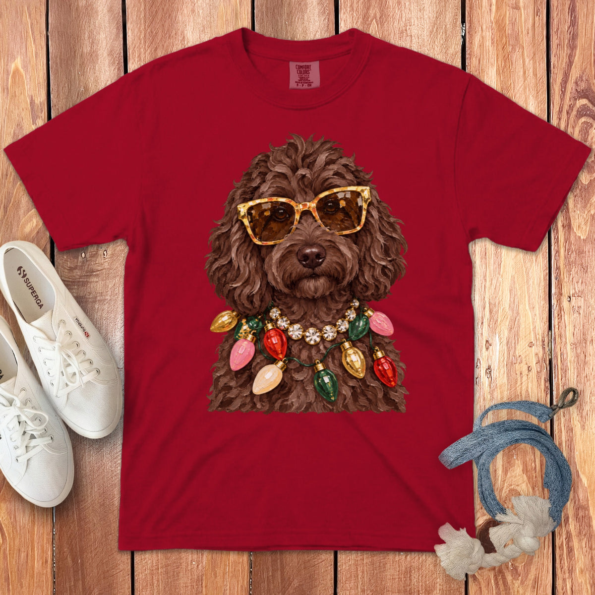 Red t-shirt with brown dog wearing sunglasses and Christmas lights necklace.