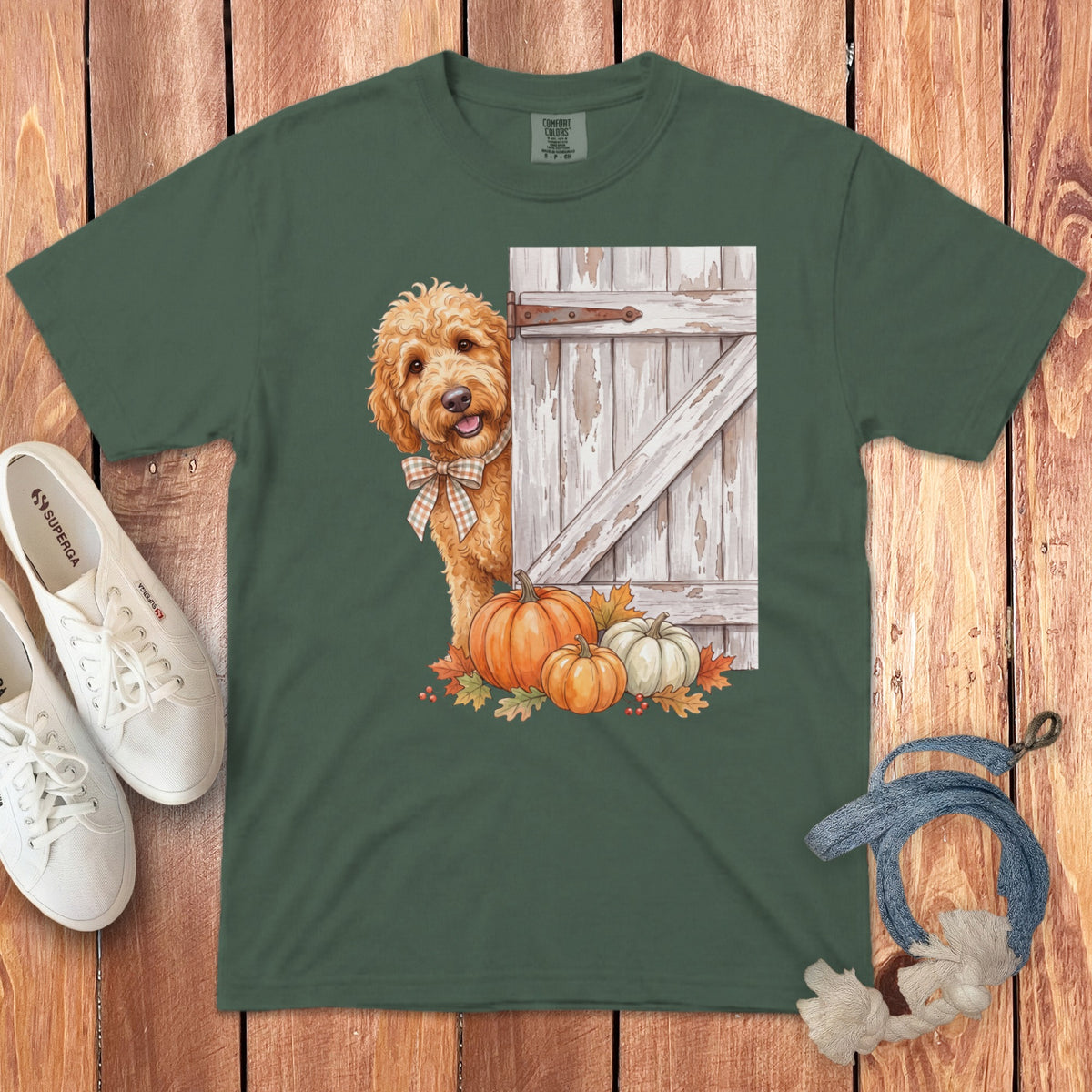 Green t-shirt with doodle dog peeking from behind a barn door with pumpkins.