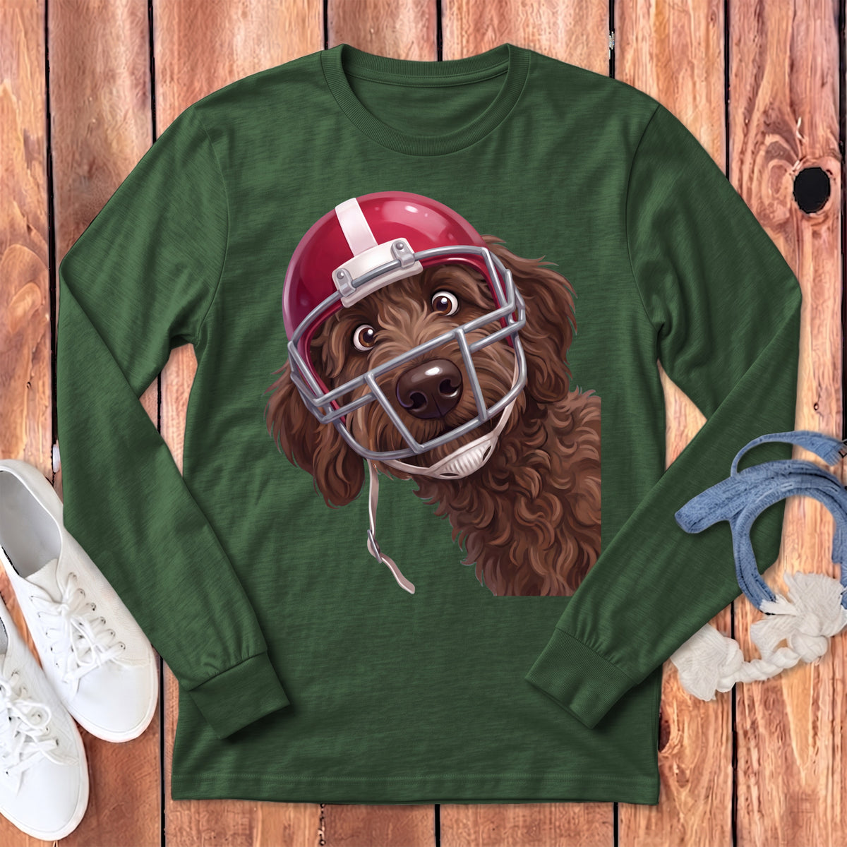 Brown doodle dog wearing a red and white football helmet and facemask on a green shirt.