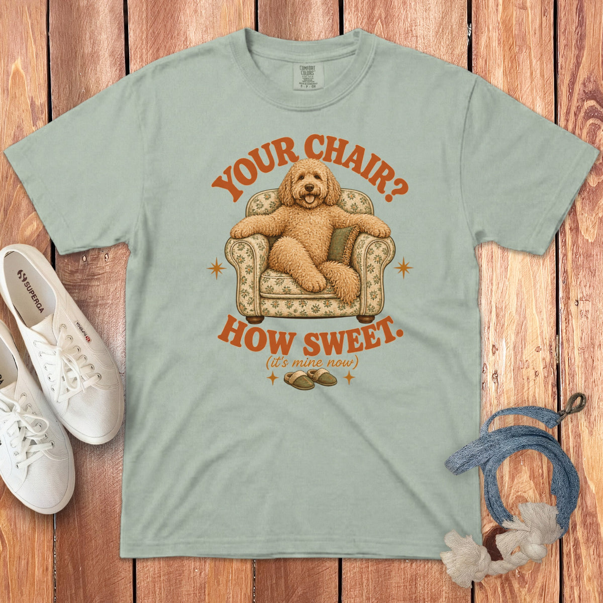 Light green t-shirt with a graphic of a golden doodle relaxing in a floral armchair.