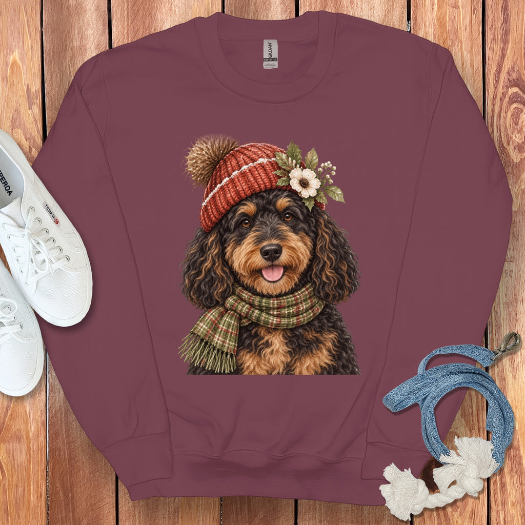 Burgundy sweatshirt with a doodle dog wearing a knit hat and scarf.