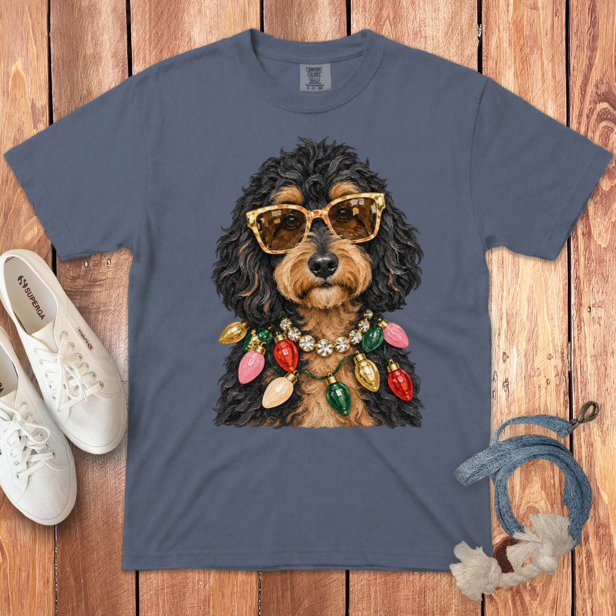 Dog with sunglasses and Christmas lights necklace on a gray t-shirt.