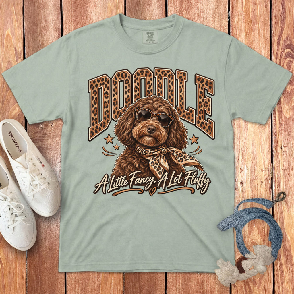 Light green t-shirt with "DOODLE" text, a fancy dog wearing sunglasses and scarf, and text "A Little Fancy, A Lot Fluffy".