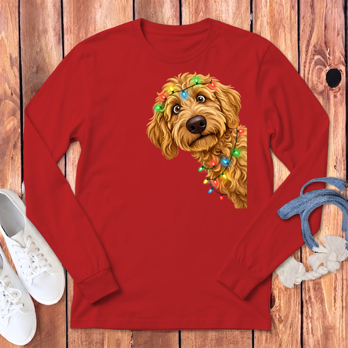 Goldendoodle wearing colorful Christmas lights on a red long-sleeve shirt.