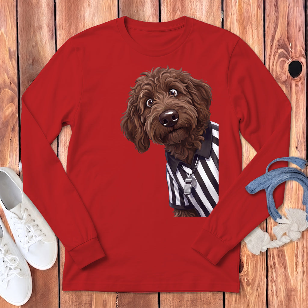 Brown doodle dog wearing a referee shirt with a whistle on a red long-sleeve shirt.