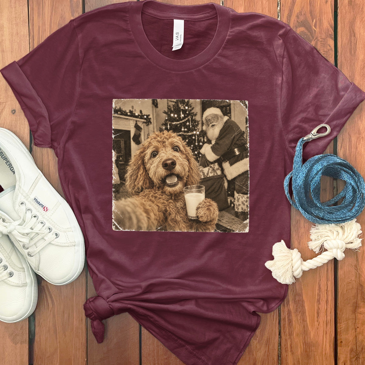 Maroon t-shirt featuring a retro graphic of a fluffy dog holding a glass of milk with Santa Claus in the background.